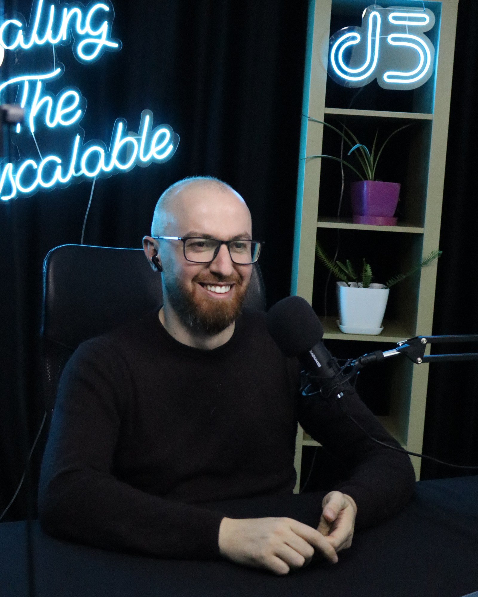 Engjell Rraklli smiling in the podcast studio